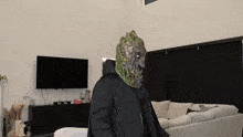 a person wearing a mask is standing in front of a television