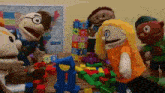 a group of puppets are playing with blocks on a wooden table .