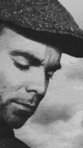 a black and white photo of a man wearing a hat .