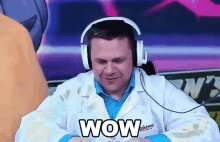a man wearing headphones and a lab coat with the word wow on it .