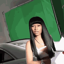 a woman with long black hair is standing in front of a green background