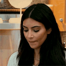 a close up of a woman with long black hair making a face .
