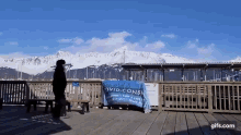 a person is standing on a wooden deck with a sign that says covid cons