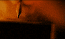 a close up of a person writing with a pencil on a piece of paper
