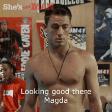a shirtless man is standing in front of a sign that says looking good there