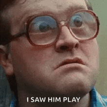 a man wearing glasses and a blue shirt is making a funny face .