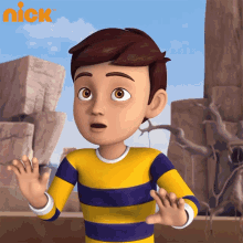a boy in a yellow and purple striped shirt is standing in front of rocks and a nick logo