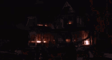 a house is on fire at night with smoke coming out of the chimney .