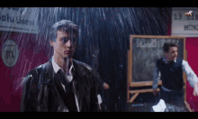 a man standing in the rain with a sign that says rtl