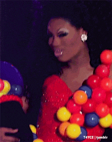a woman in a red dress is surrounded by colorful balloons and a tumblr logo