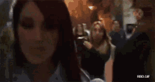 a woman with red hair is smiling in front of a crowd