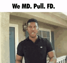 a man in a black shirt is standing in front of a house with the words we md pull fd written above him .