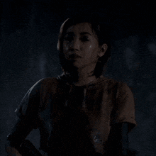 a woman is standing in a dark room looking at the camera .