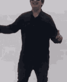 a man in a black shirt is giving a thumbs up .