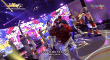 a group of people are dancing on a stage with the words kung di mo to gusto huey huey on the bottom