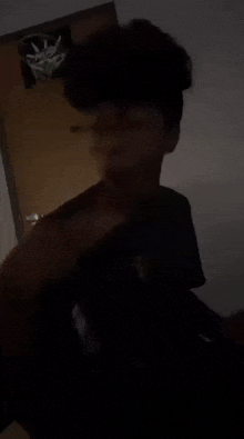 a person with glasses is standing in a dark room .