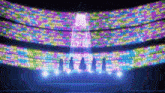 a group of people standing on a stage in front of a wall of colorful lights