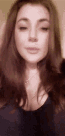 a close up of a woman 's face with a necklace on