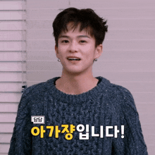 a young man wearing a blue sweater with korean writing on the front
