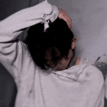 a man in a white shirt is holding his head with his hands