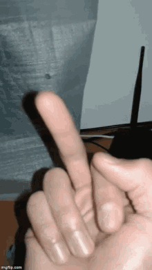 a close up of a person 's hand making the middle finger sign