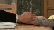 a man and woman are holding hands at a table