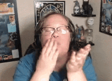 a woman wearing glasses and headphones is blowing a kiss at the camera