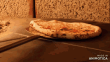 a pizza is being taken out of the oven and the words made in animotica can be seen in the corner