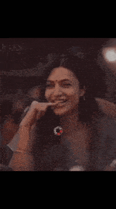 a close up of a woman 's face with her hand in her mouth .