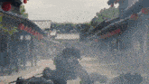 a group of people are laying on the ground in front of a row of buildings with red lanterns hanging from the roofs