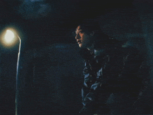 a man looks up at the moon in the dark