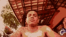 a man without a shirt is taking a selfie .