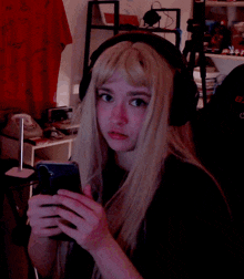a woman wearing headphones is holding a cup of something
