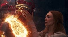 a woman is touching a man 's head with a heart coming out of his chest .