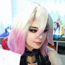 a woman with pink and white hair is wearing a black top