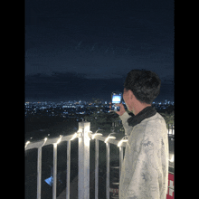 a person taking a picture of a city with a cell phone