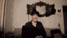 a man is sitting on a couch in front of a mirror .