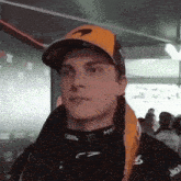 a man wearing a hat that says mclaren is looking at the camera