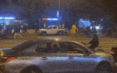 a group of people are running across a crosswalk at night