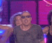 a man and woman are dancing in front of a sign that says moze da me muci