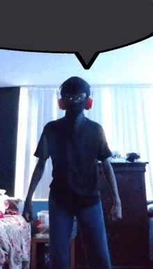 a man wearing headphones and a mask stands in a room