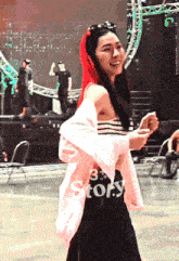 a woman with red hair is wearing a pink jacket that says story