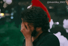 a man with a beard is wearing a santa hat and has the hashtag avantika_0902 on the bottom