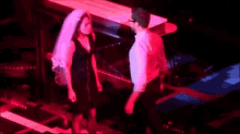 a man and a woman are dancing on a stage in a dark room .
