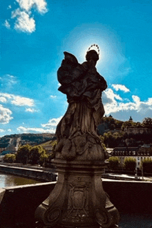 a statue of a woman with a crown on her head in front of a blue sky