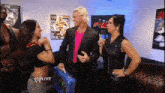 a man in a pink shirt holds a blue briefcase that says raw on it