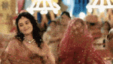 a woman in a red dress is dancing in front of a crowd .