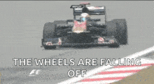 a race car is driving down a track with the words the wheels are falling off below it
