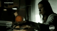 a woman is sitting at a desk using a laptop computer .