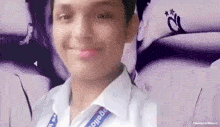 a young man wearing a white shirt with a lanyard around his neck that says college